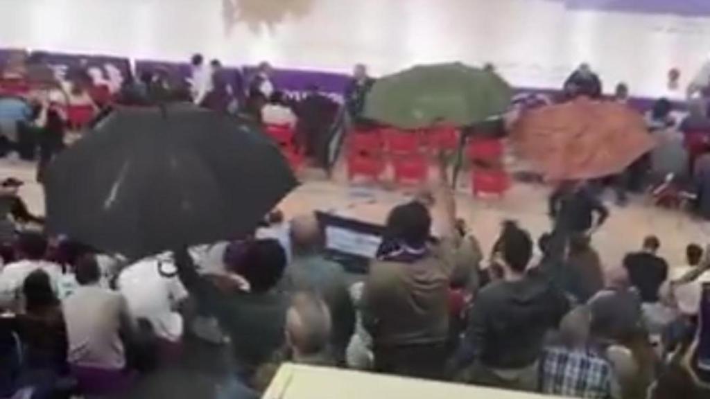 Aficionados con paraguas dentro del polideportivo