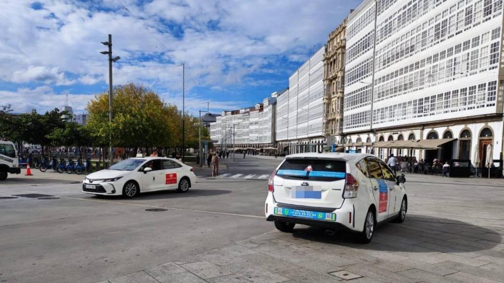 Un taxi circula por la Marina, en A Coruña, y otro espera en la parada.