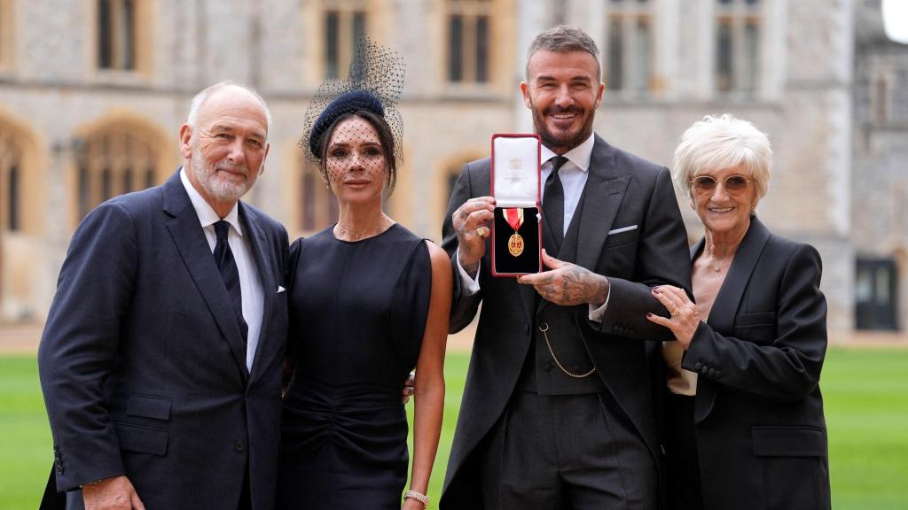 Sir David Beckham, junto a su esposa Victoria y sus padres, Ted y Sandra, tras ser nombrado caballero británico