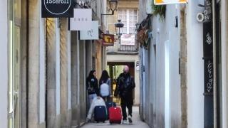 Turistas con equipaje caminan por una calle del centro de A Coruña.