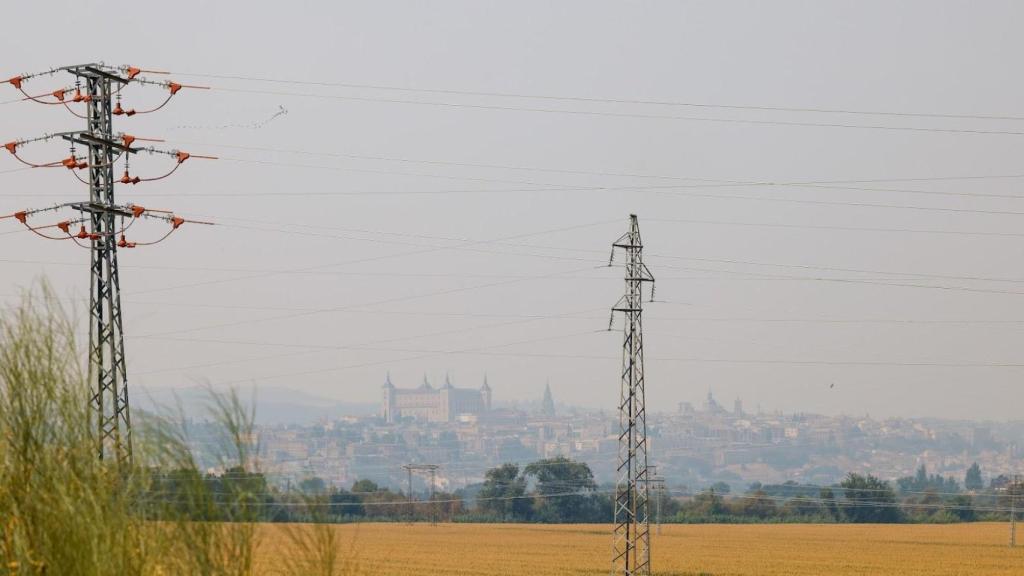 Varias torretas de electricidad, con Toledo al fondo.