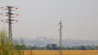 Varias torretas de electricidad, con Toledo al fondo.