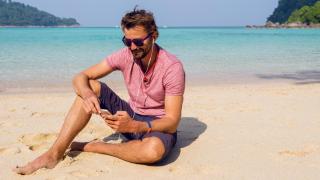 Una persona utilizando su teléfono móvil en la playa.