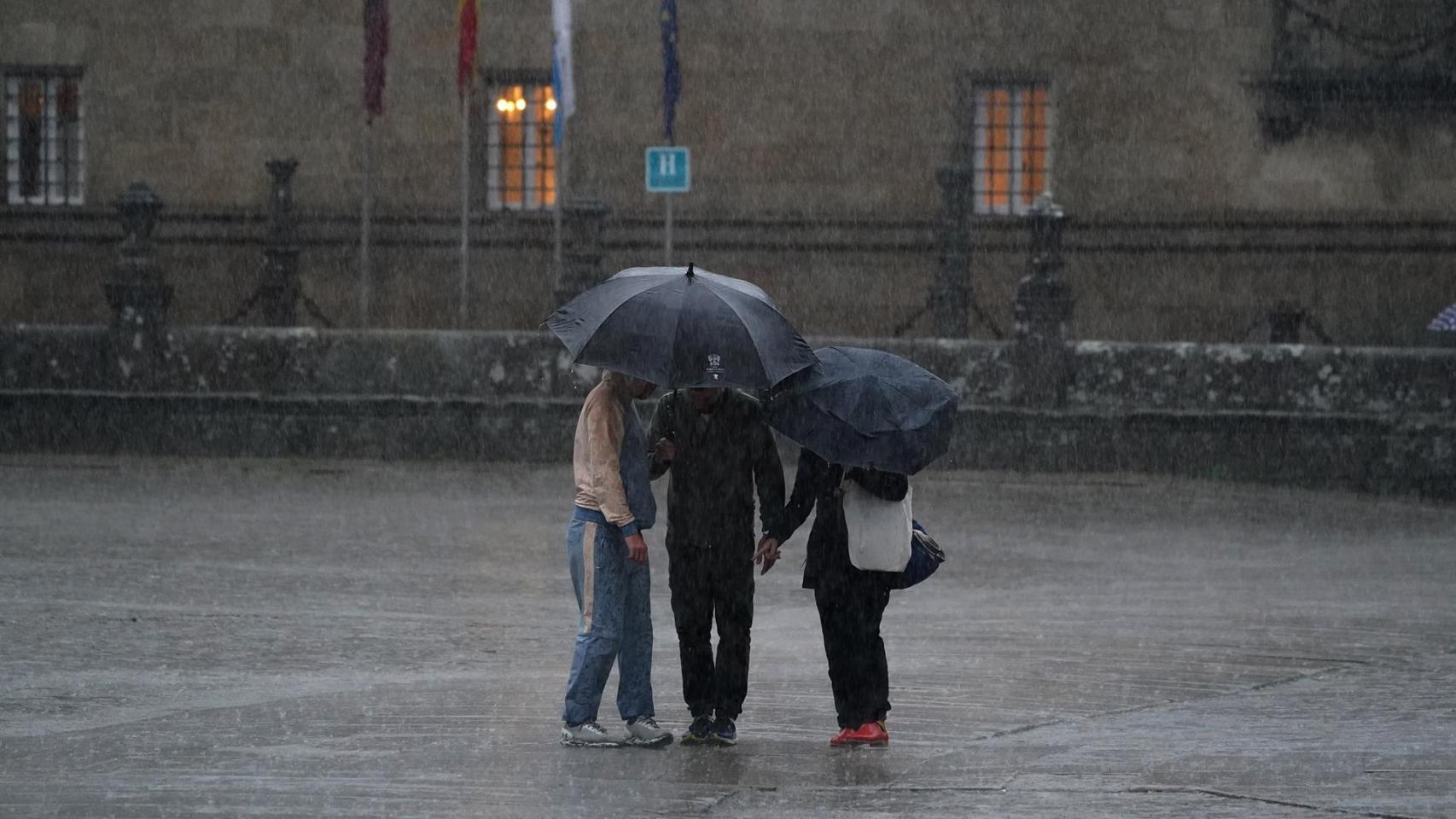 Varias personas con paraguas durante el paso de la borrasca Aline.