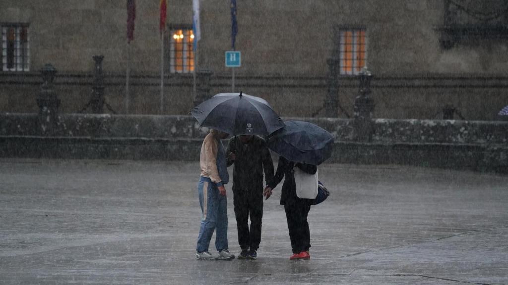 Varias personas con paraguas durante el paso de la borrasca Aline.