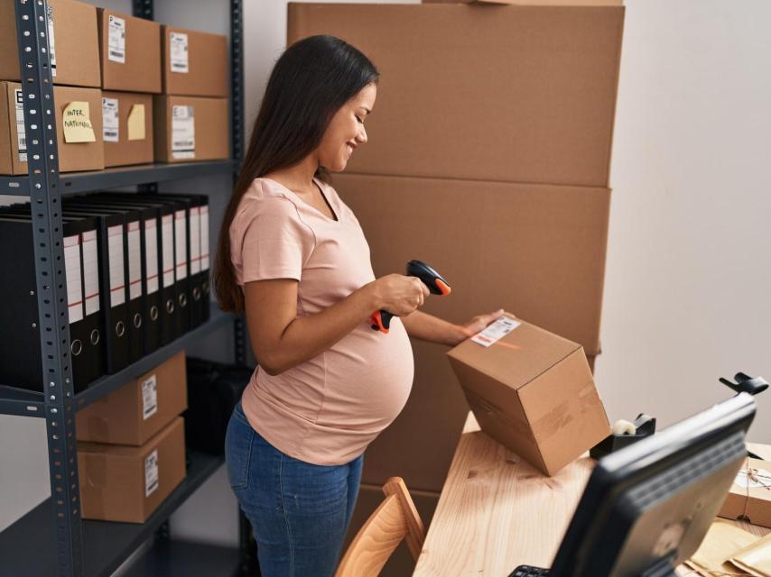 Imagen de archivo de una empleada en estado en su centro de trabajo.