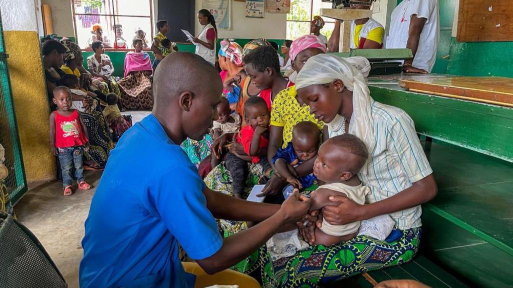 Uno de los médicos vacunando a un bebé.