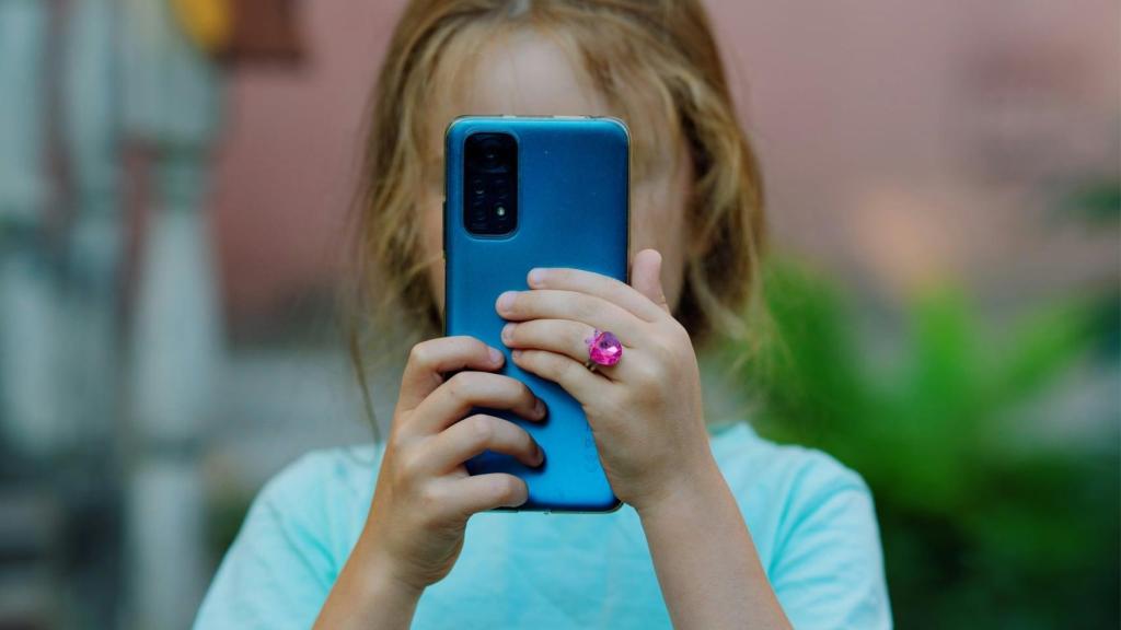 Una niña usando un móvil