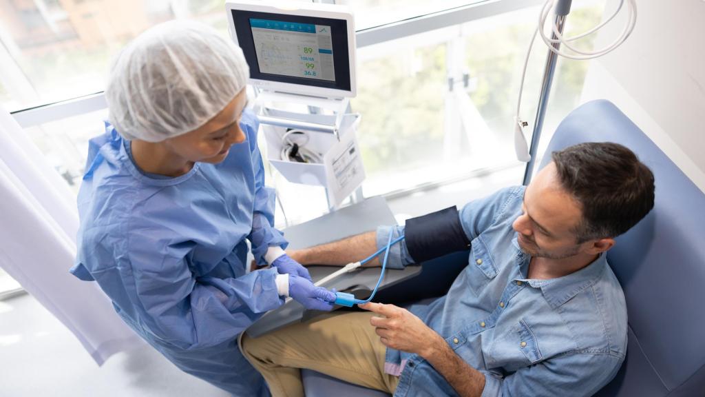 Enfermera colocando un oxímetro de pulso en el dedo de un paciente.