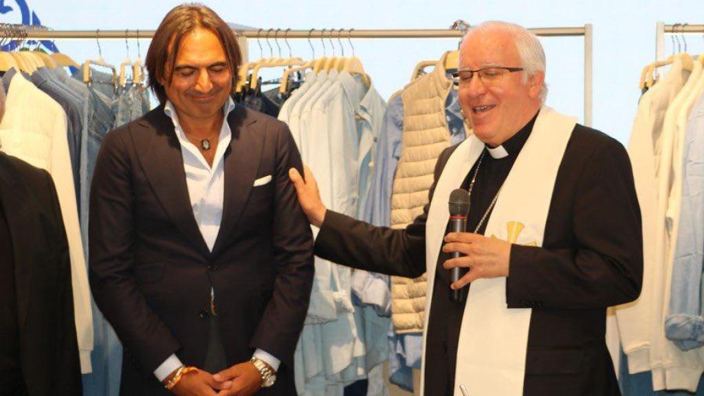 Álvaro Moreno, junto a un sacerdote, durante la inauguración de una de sus tiendas.