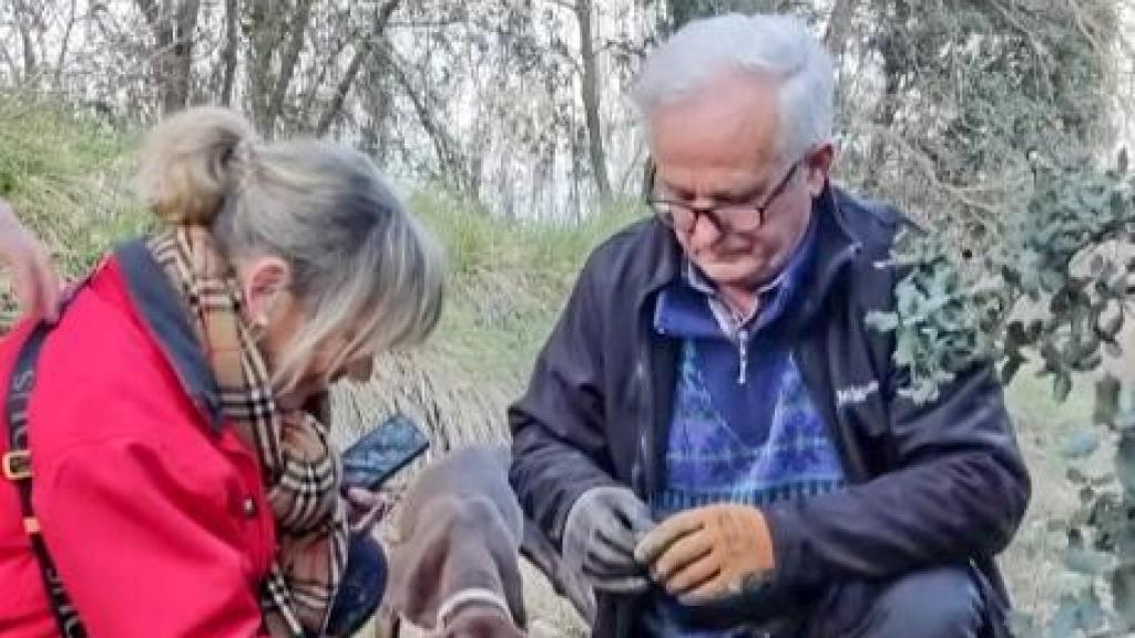 El cazador Vicente con su perrita Boli mostrando a una visitante cómo extraer la trufa con el puñal.