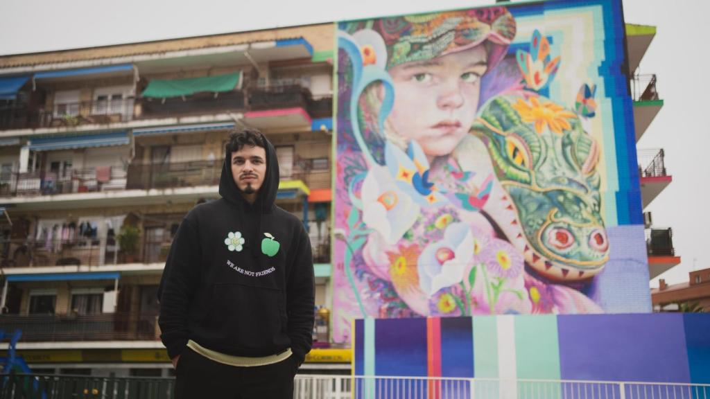 El artista Murfin junto a su mural Niños Perdidos, ubicado en Fuenlabrada.