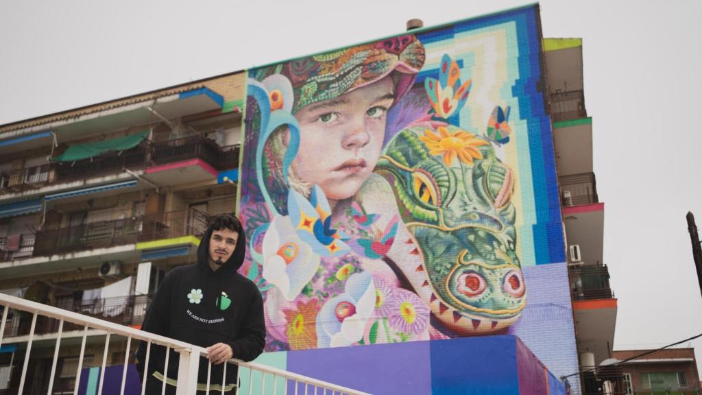 El artista Murfin junto a su mural Niños Perdidos, ubicado en Fuenlabrada.