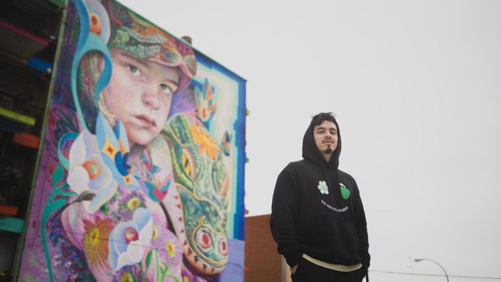 El artista Murfin junto a su mural Niños Perdidos, ubicado en Fuenlabrada.
