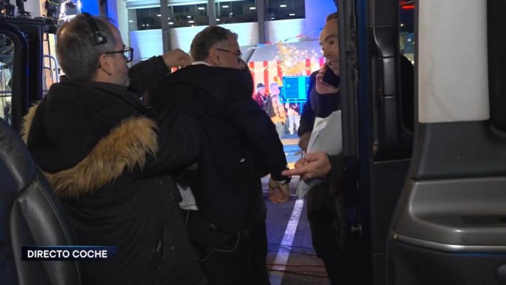 Varios técnicos intentan recolocar el micrófono a Jorge Javier Vázquez al llegar en coche a las instalaciones de Mediaset.