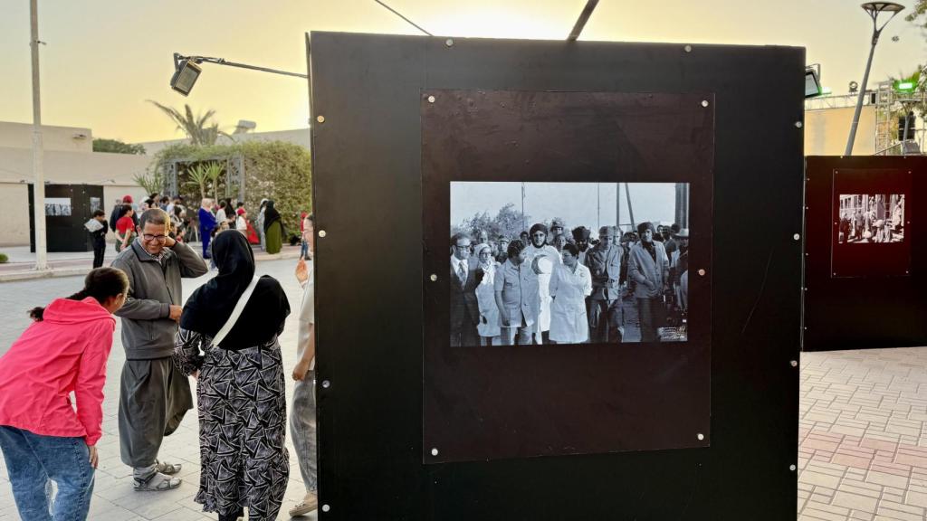 Una familia visita una de las diversas exposiciones fotográficas de la Marcha Verde que pueden verse en el centro de Dajla.
