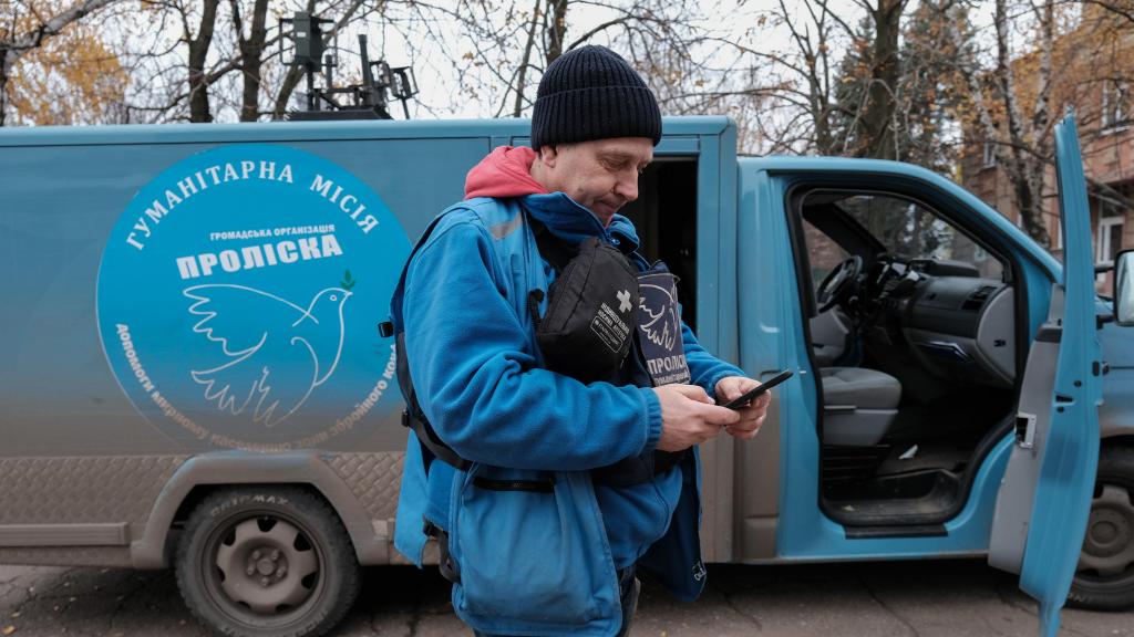 Evgeny Tkachev, trabajador humanitario ucraniano de misión Proliska, junto al vehículo de evacuación que sería atacado por Rusia una hora después.