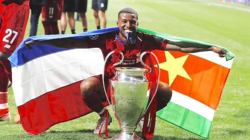 Wijnaldum posa con una bandera de Países Bajos y Surinam.