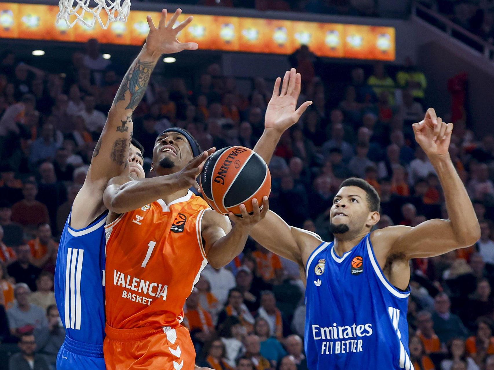 Kameron Taylor intenta encestar ante Deck y Tavares.