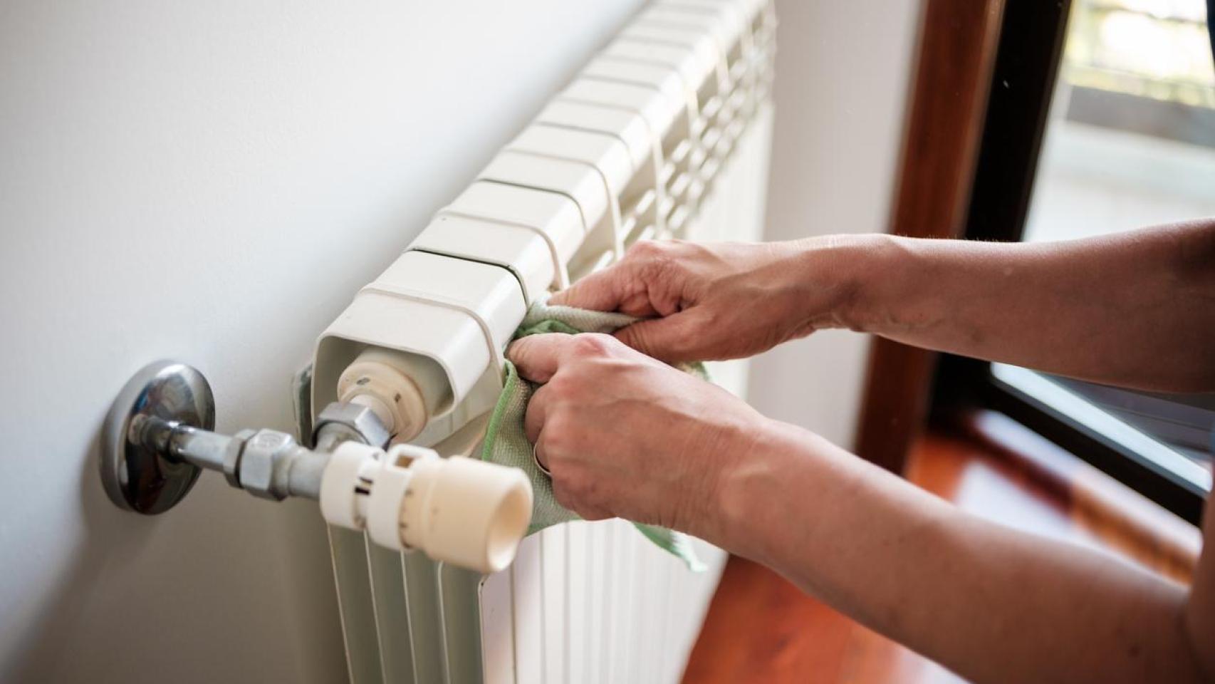 Una mujer limpiando el radiador.