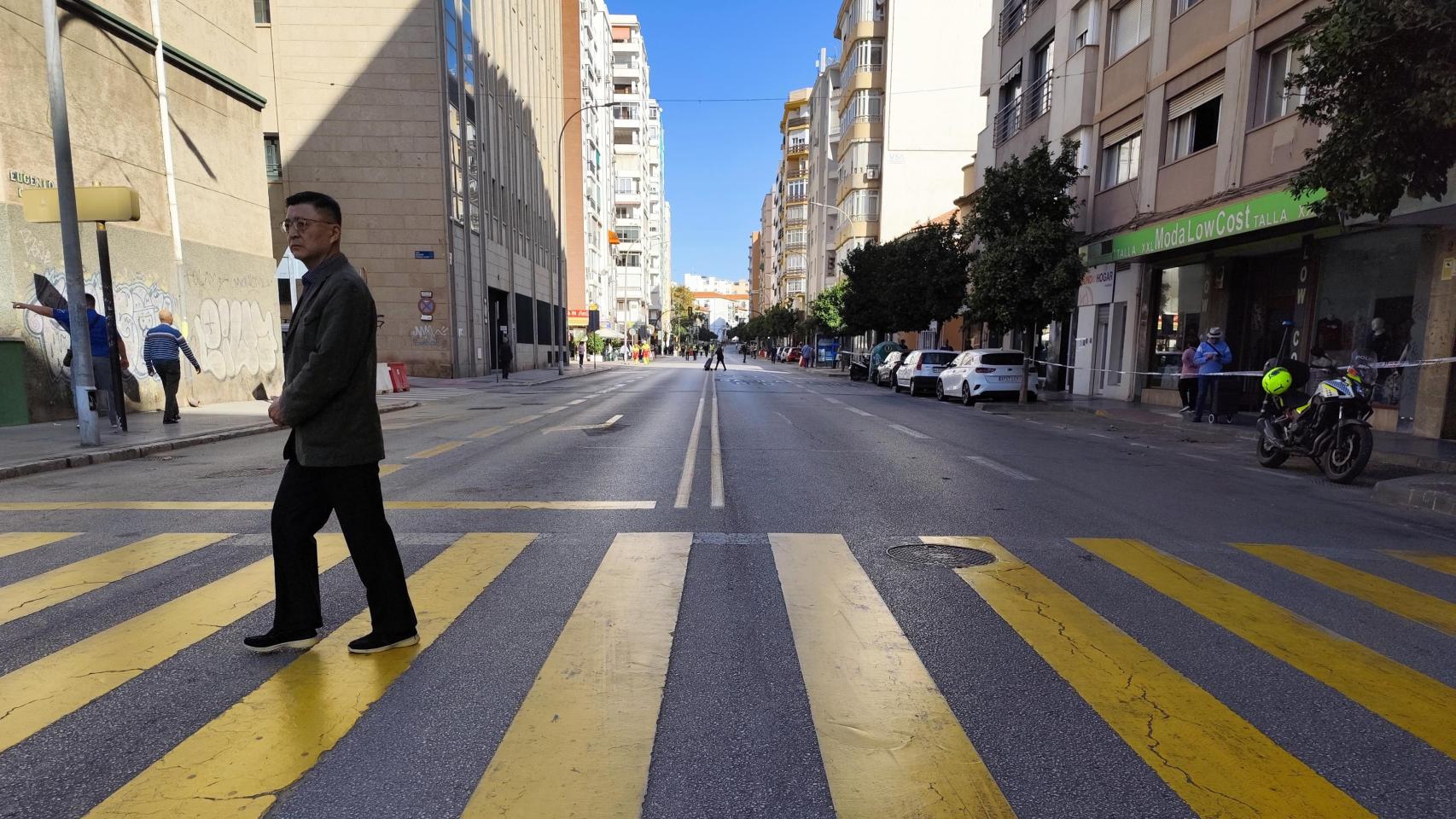 Una persona cruza el paso de peatones de la calle Eugenio Gross, ya cortada al tráfico por las obras del Metro de Málaga.