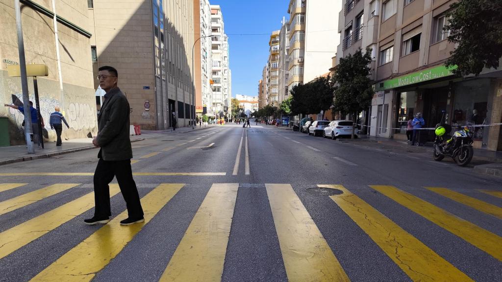 Una persona cruza el paso de peatones de la calle Eugenio Gross, ya cortada al tráfico por las obras del Metro de Málaga.