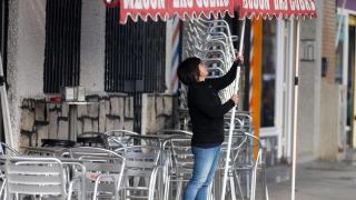 Una camarera levanta el toldo, en Madrid.