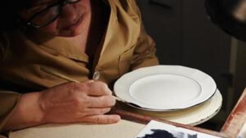 Una operaria haciendo una pieza de una vajilla de La Cartuja.