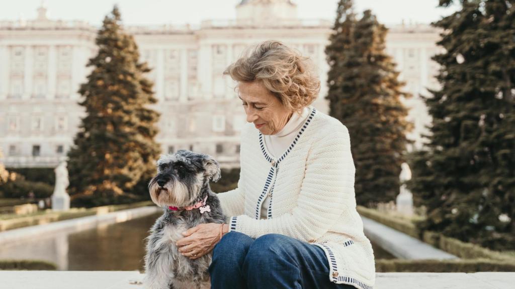 Julia Navarro posa junto a su perra con el Palacio Real de fondo.