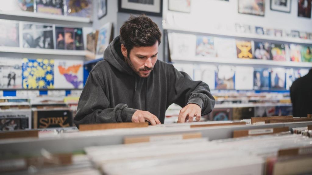 Guillermo busca entre los discos de la tienda.