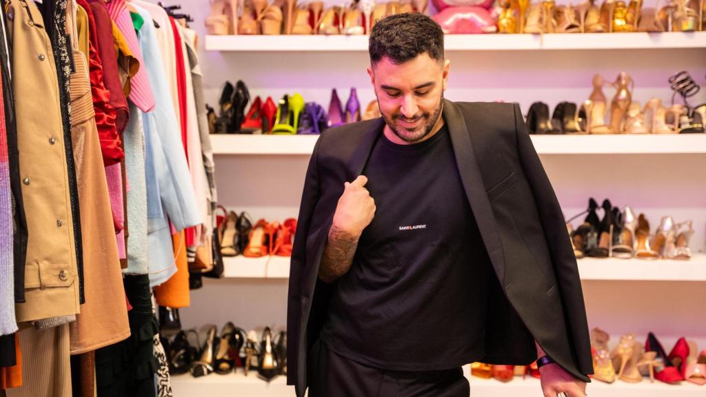 El profesional ante una estantería repleta de zapatos en su estudio.