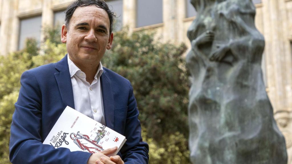 Paco Gómez posa con su libro junto a la estatua de Santa Teresa de Jesús ubicada frente a la casa convento en la que residió