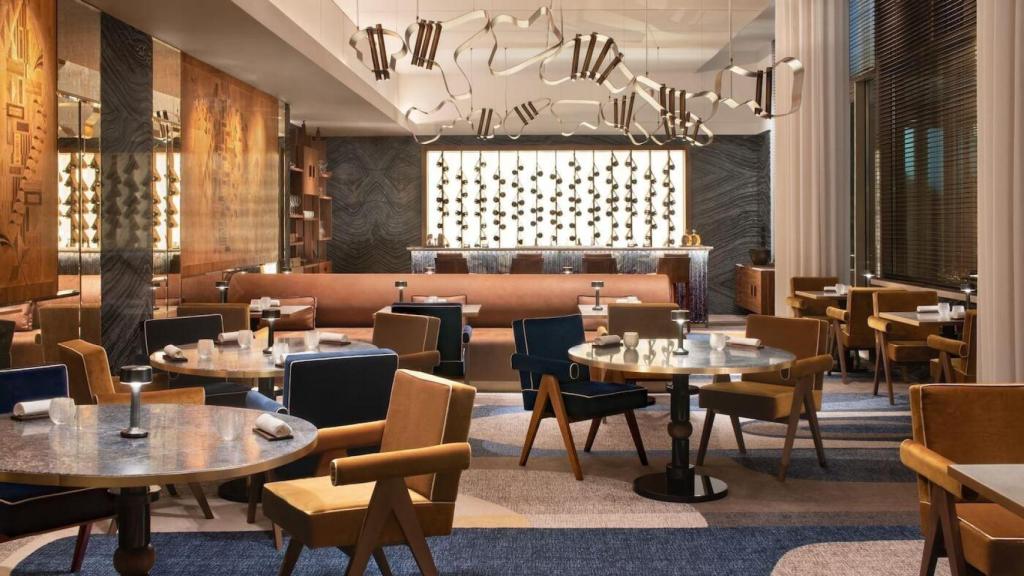 El comedor de CURA, marcado por la luz cálida y el mármol azul que define su estética.