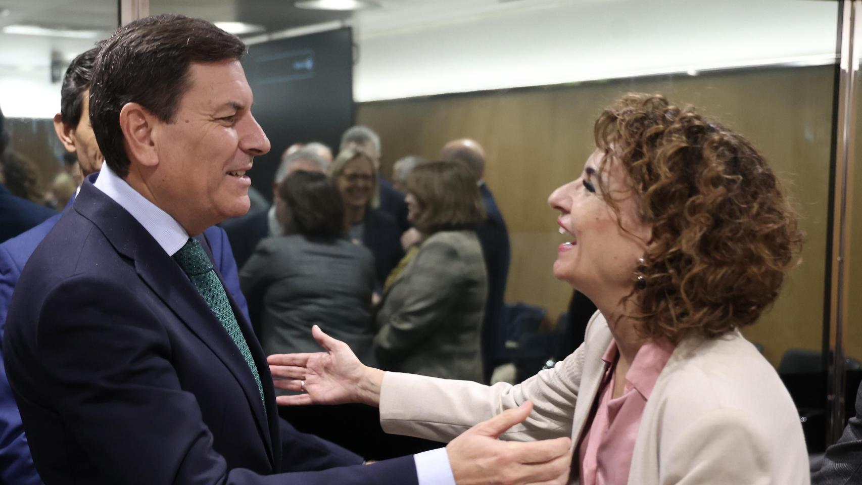 El portavoz y consejero de Economía y Hacienda de la Junta de Castilla y León, Carlos Fernández Carriedo, saluda a la ministra de Hacienda, María Jesús Montero, al inicio de la reunión del Consejo de Política Fiscal y Financiera de este lunes