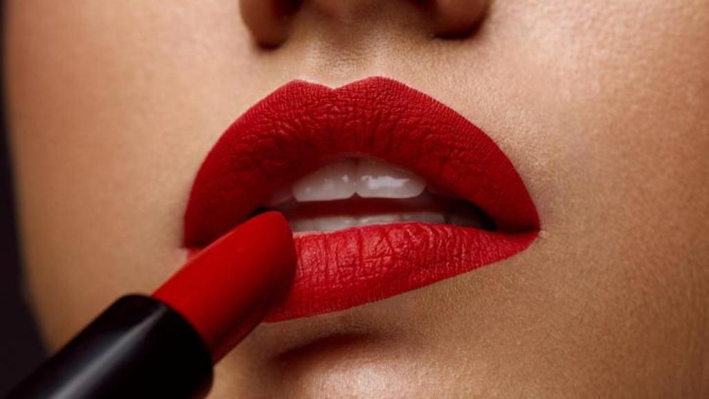 Mujer pintándose los labios de rojo.