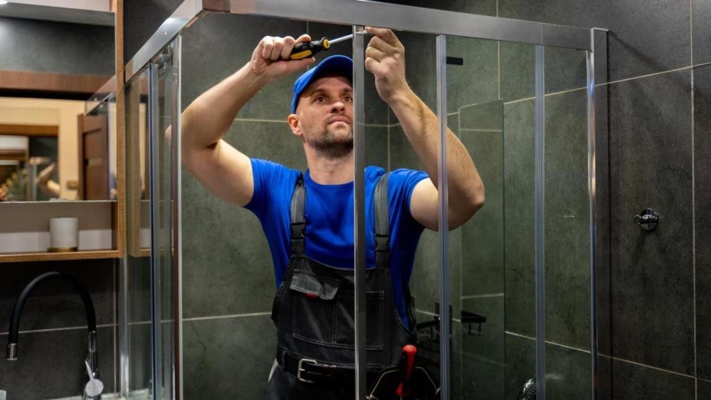 Un hombre reparando una ducha.