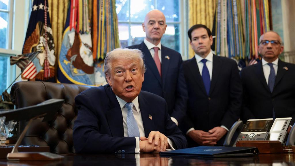 Trump, compareciendo en el Despacho Oval mientras Infantino le observa a su espalda