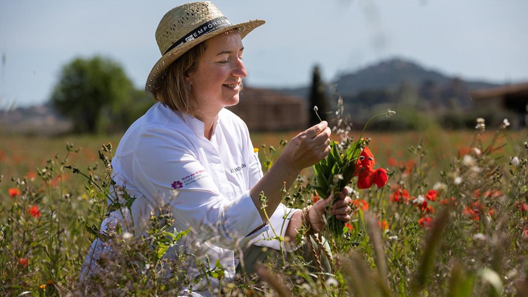 La chef catalana Iolanda Bustos recolectando flores que integrará en su cocina.