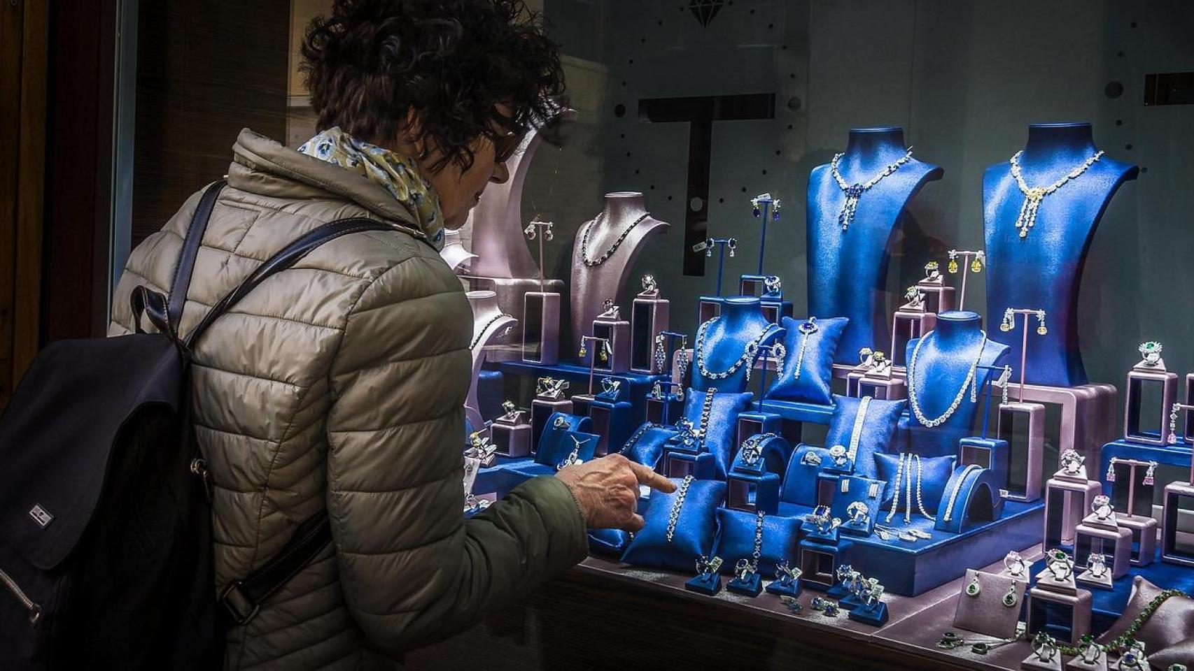 Una mujer mirando el escaparate de una joyería.