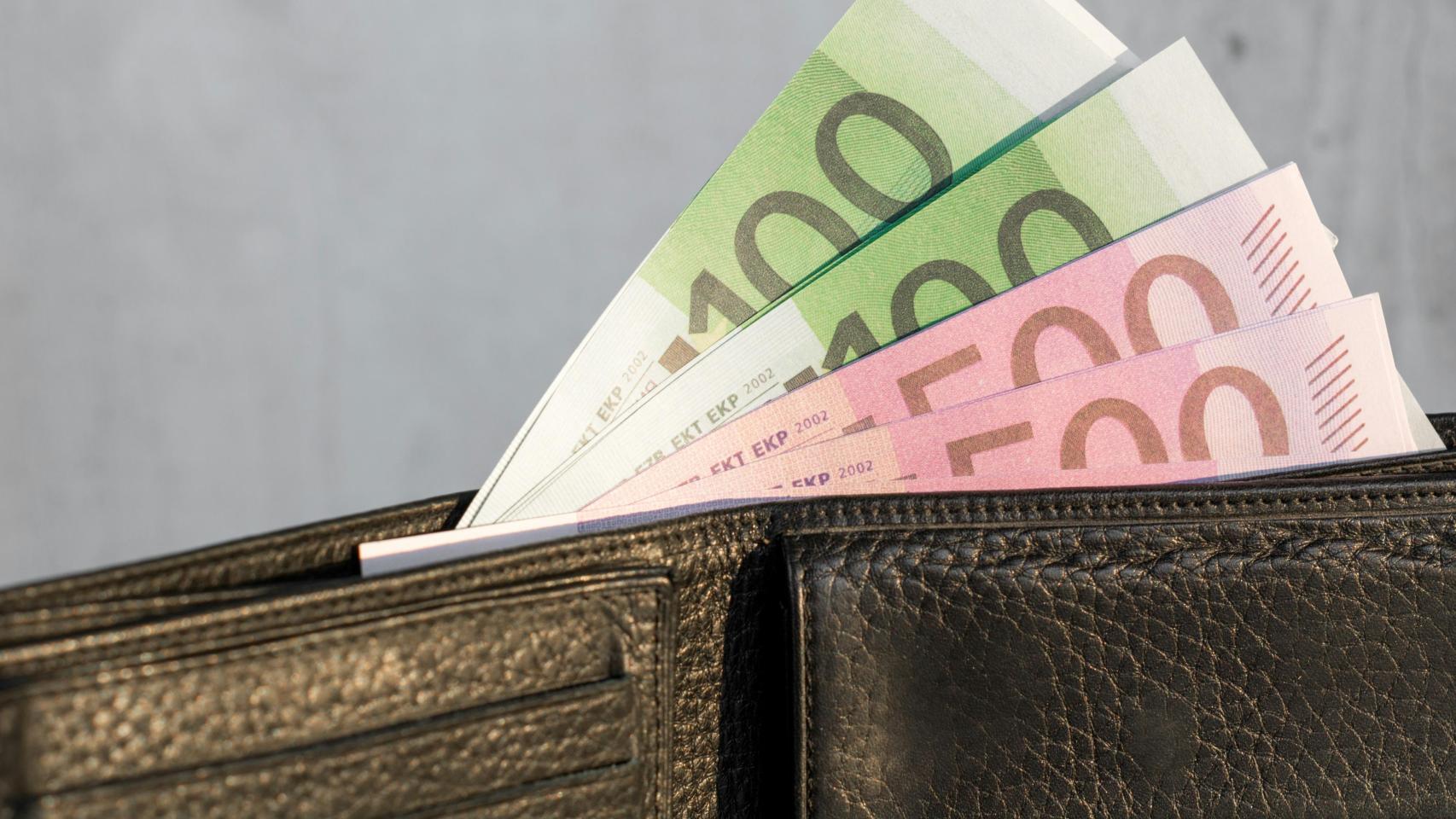 Una cartera de bolsillo con billetes de 100 y 500 euros.