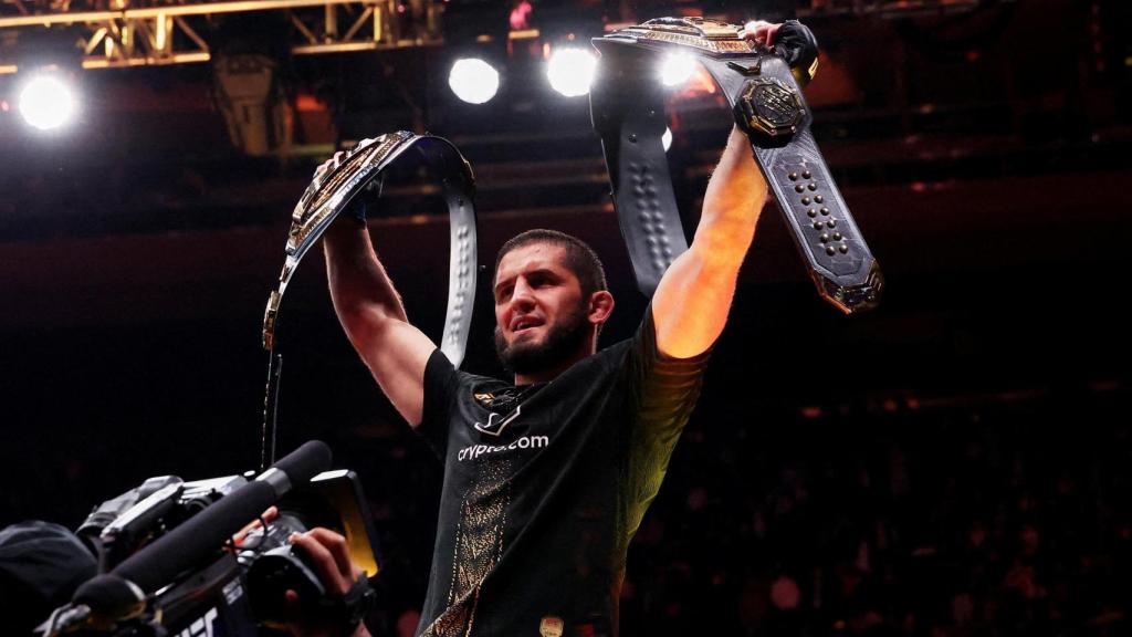 Islam Makhachev celebra con sus dos títulos de la UFC