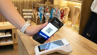 Una persona utilizando el código QR de MercaNaVila