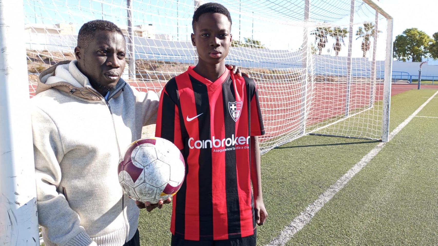 Jonás posa con su hijo, Winston, luciendo la equipación del CD Puebla de Soto con el que sueña que le permitan jugar esta temporada.