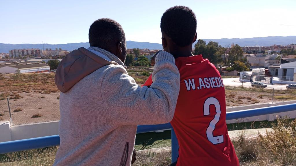 Jonás abraza a su hijo mientras observan juntos una vista panorámica de Alcantarilla.