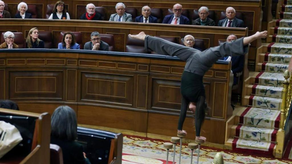 Una acróbata hace contorsiones ante el hemiciclo del Congreso, para recordar los 50 años de la muerte de Franco.