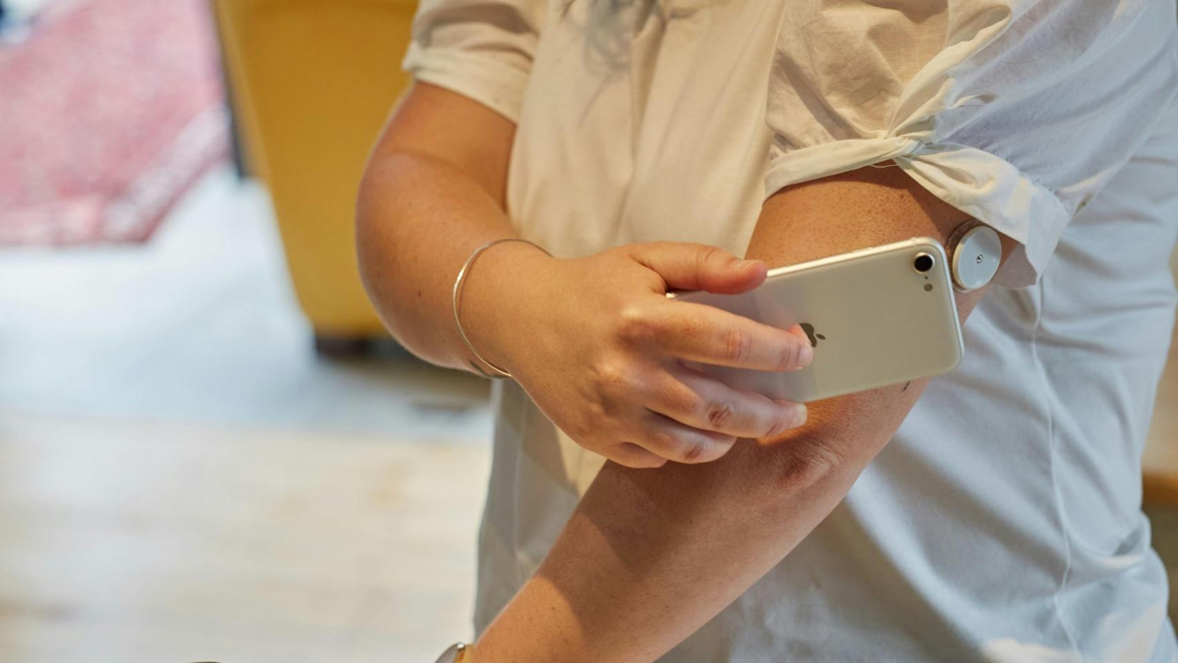 Imagen de archivo de una chica haciendo una comprobación de su sensor de glucosa.