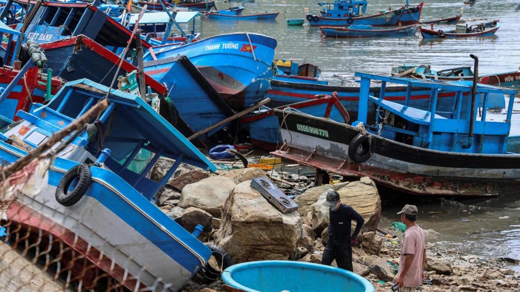 Dos personas caminan por la costa de un pueblo pesquero de Vietnam tras las lluvias torrenciales de estos días.