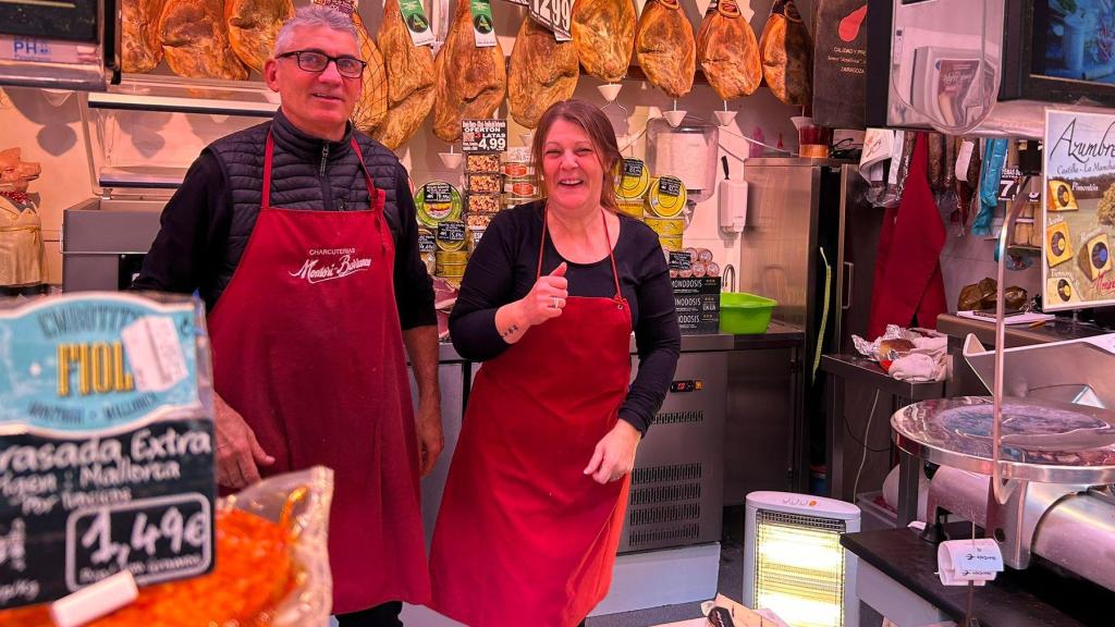 Javier junto a su compañera, ambos con ropa abrigada y junto a una estufa.