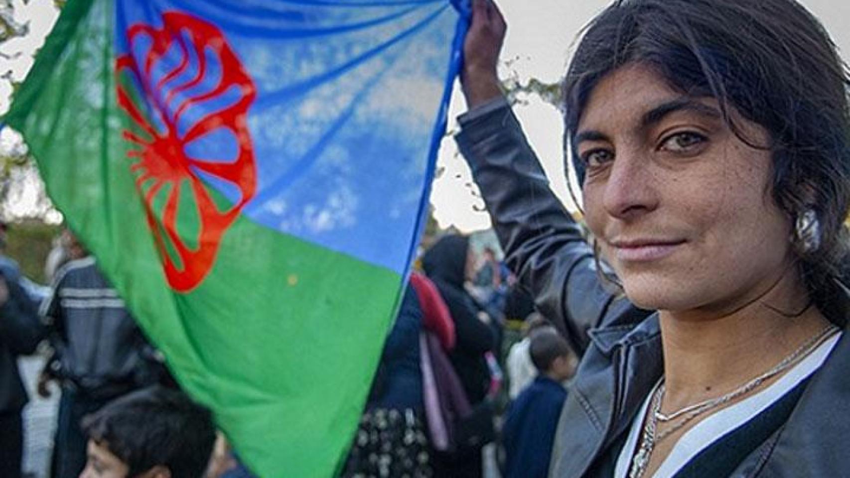 Una persona sosteniendo una bandera gitana.