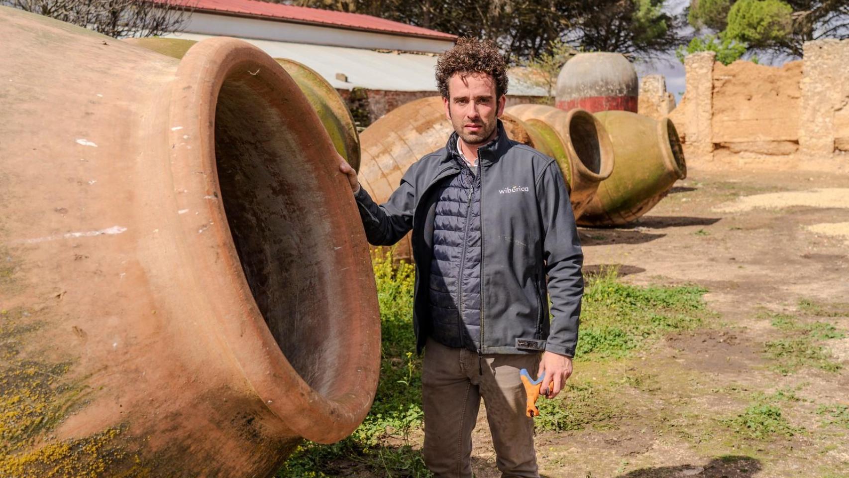 Antonio Serrano junto a varias de las tinajas que emplea para hacer vino en Villarrobledo (Albacete).